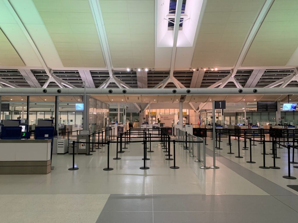 empty check-in area of a modern airport with sleek design and organized layout.