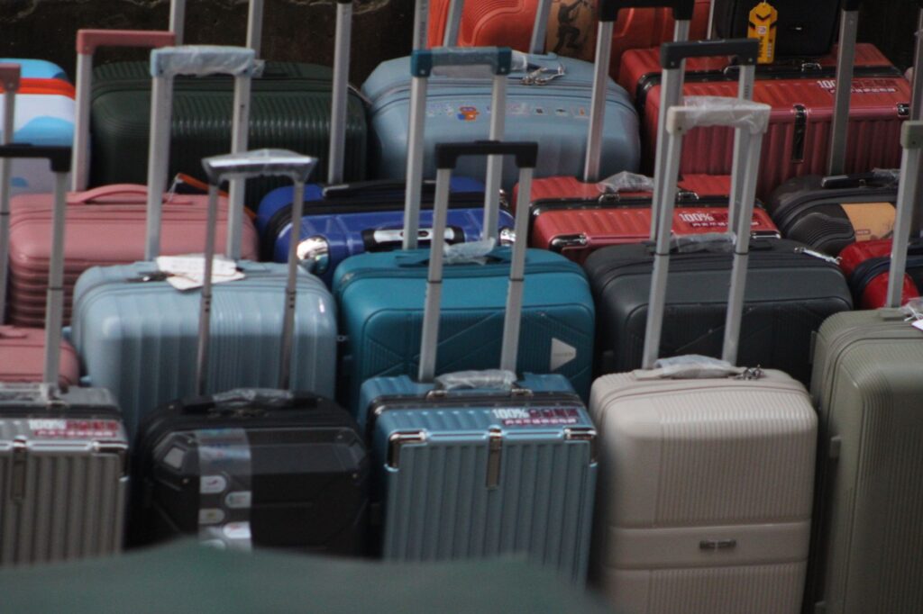 a variety of colorful suitcases with handles extended, ready for travel.