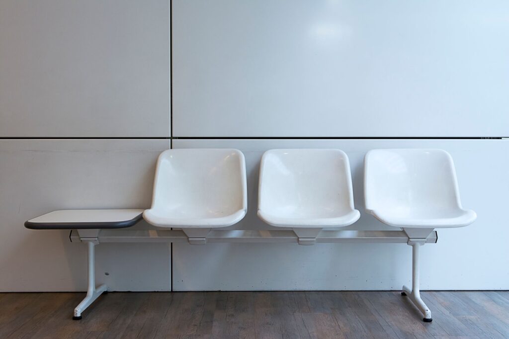 a minimalist setup of white plastic waiting room chairs in a modern interior.