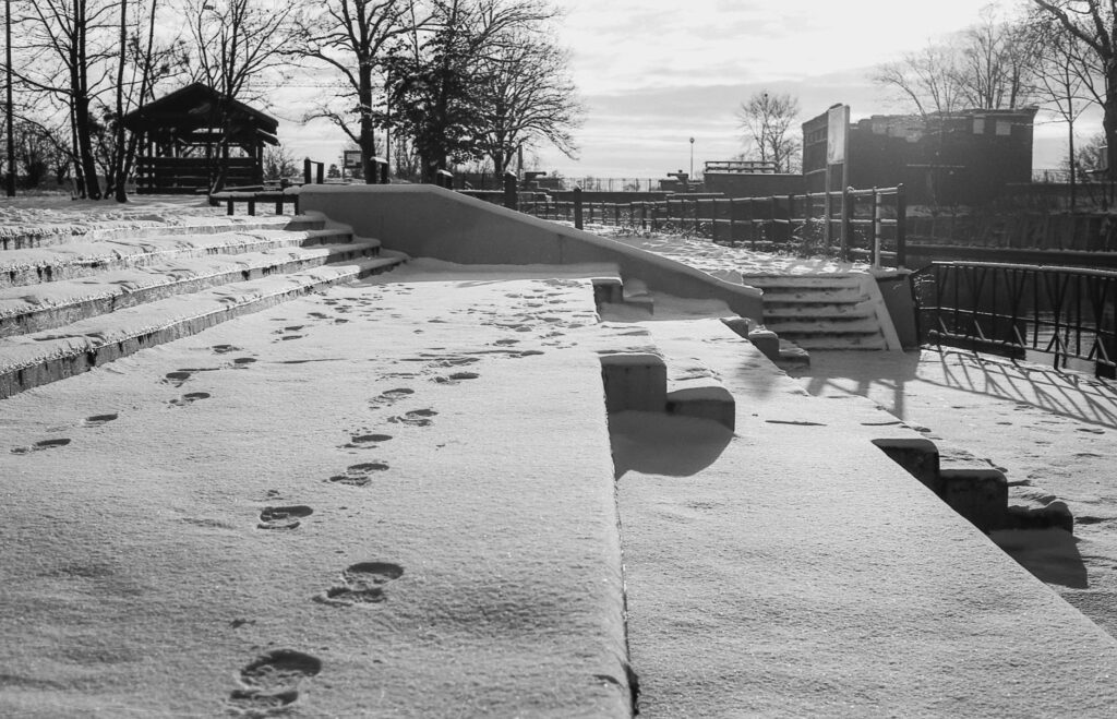 snow-covered footsteps on stairs in gdańsk, creating a tranquil winter urban scene.