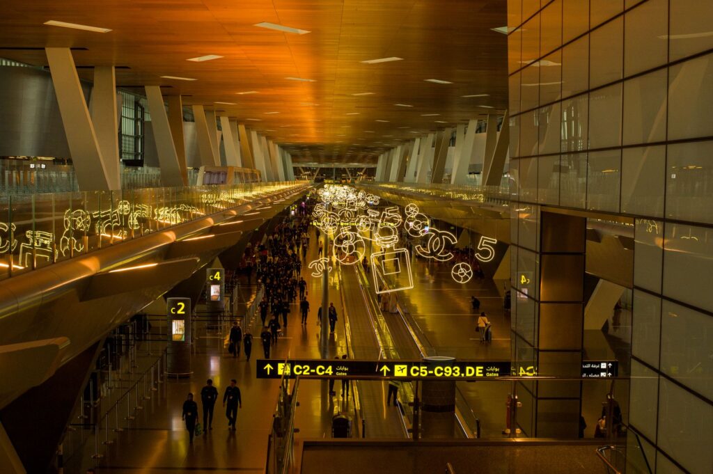 busy airport terminal featuring modern architecture and vibrant lighting decorations.