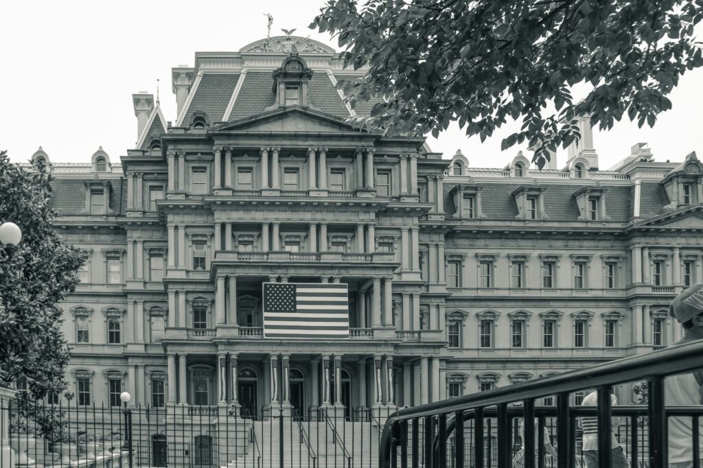 view of the eisenhower executive office building in washington with american flag.