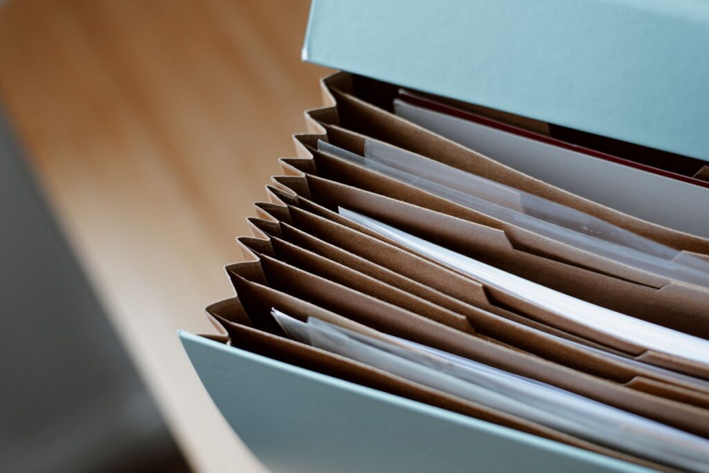 high angle of opened briefcase for documents with papers accosted in order placed on wooden table