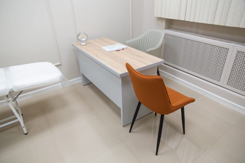 minimalist office interior featuring a desk with chairs, suitable for healthcare or office settings.