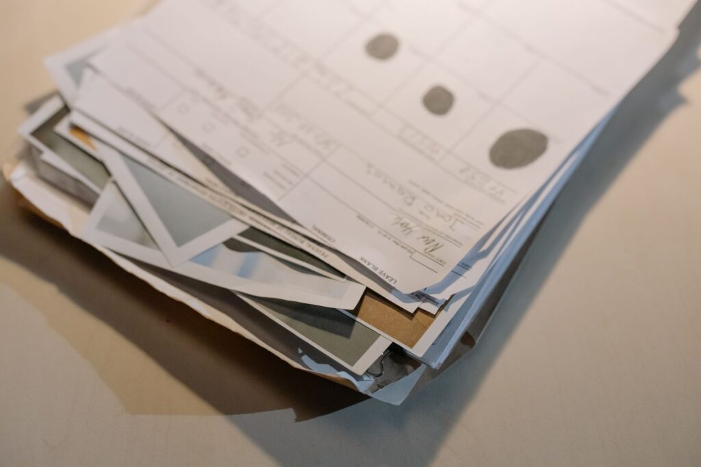 close-up view of a stack of various papers and documents on a desk surface.