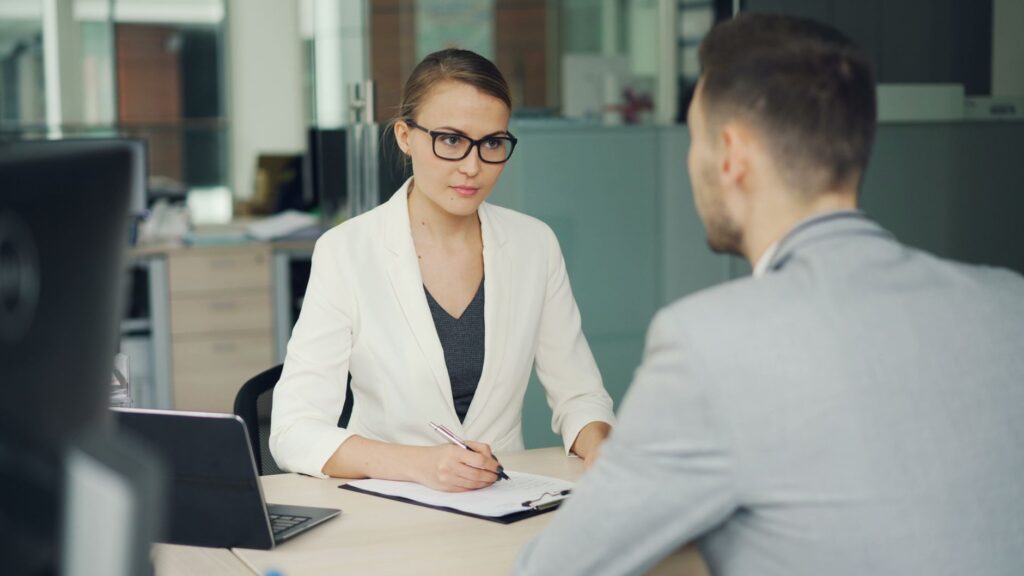 two professionals in a serious business meeting at a modern office setting.