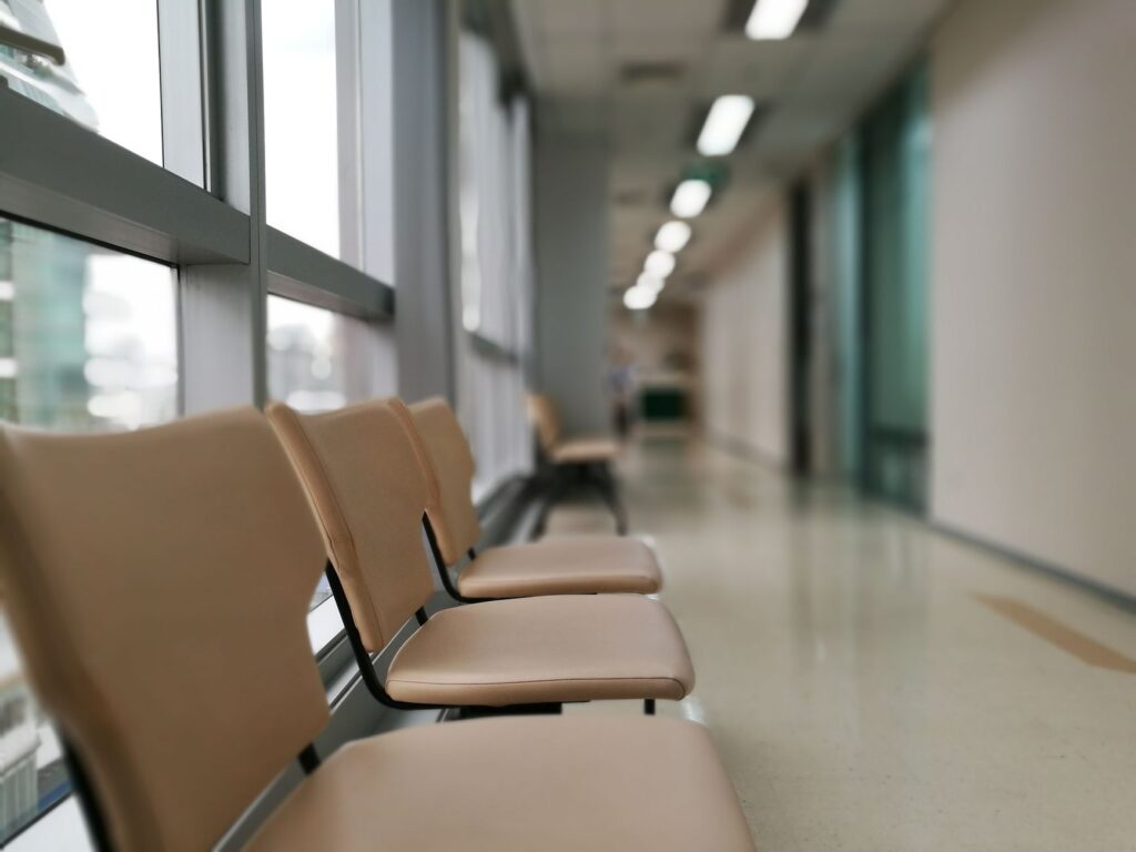 row of empty chairs in a hospital corridor, soft lighting and modern interior design.